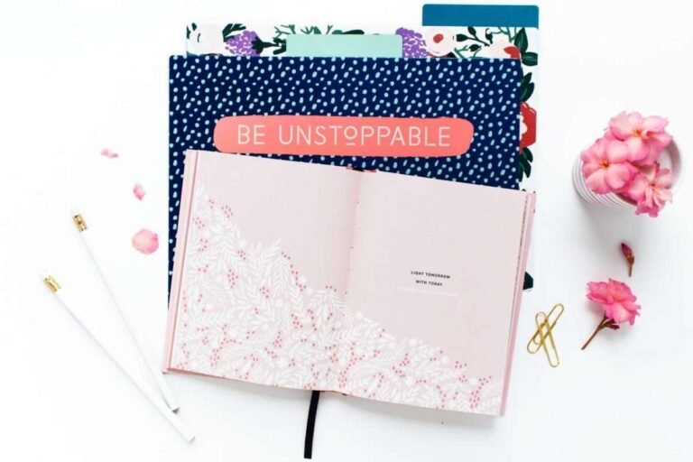 stack of journals on white desk