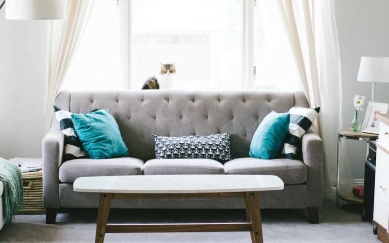 a grey sofa with turquoise pillows